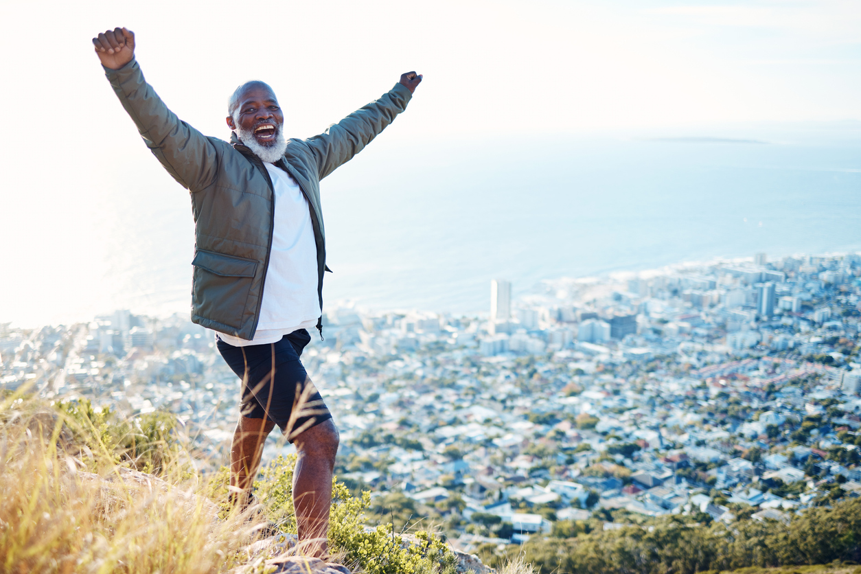 black man on mountain and excited